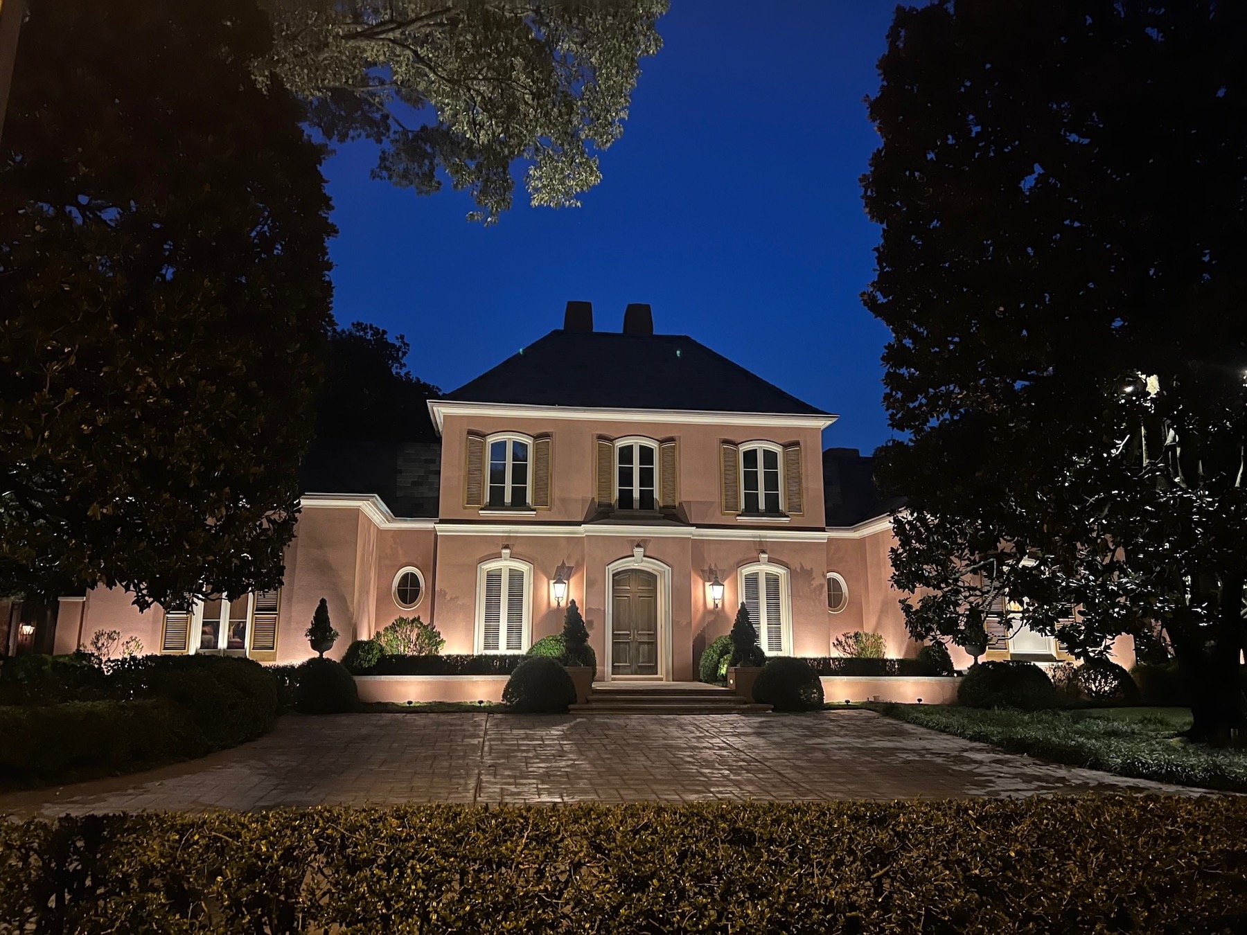 outdoor lights on front of home with large paver driveway 