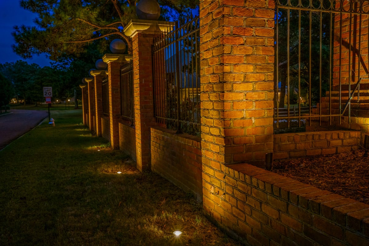 Commercial landscape lighting brick gate uplighting